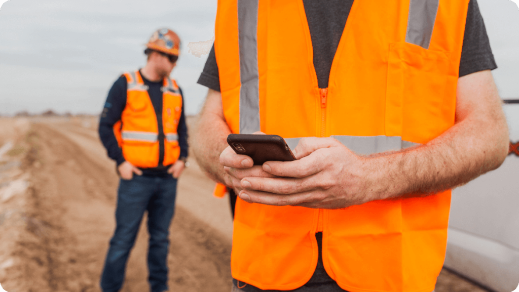 contractor using phone on jobsite.