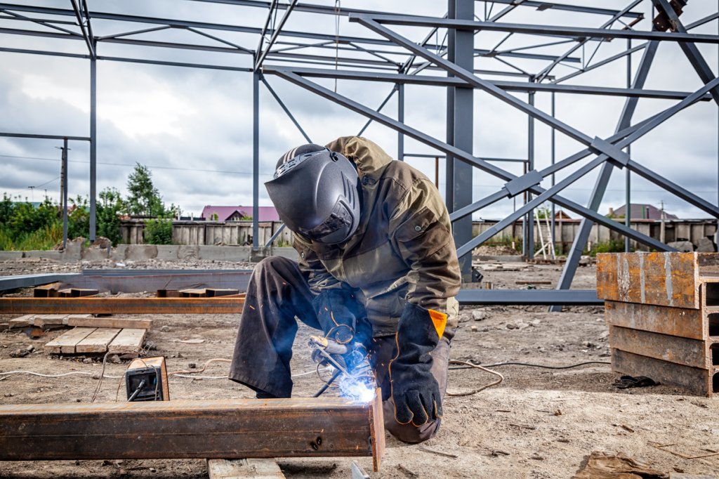 construction worker welding on construction site.