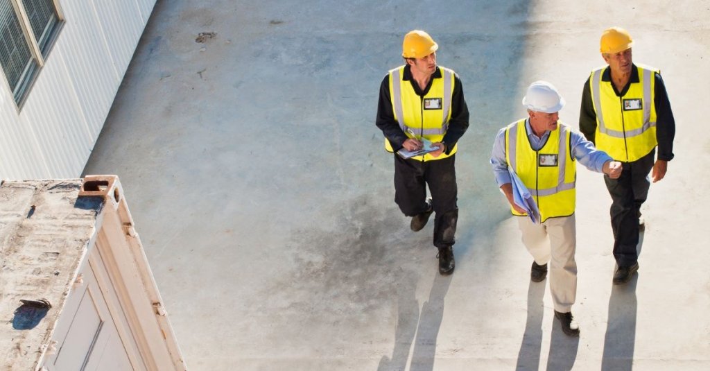 three construction workers walking on jobsite.