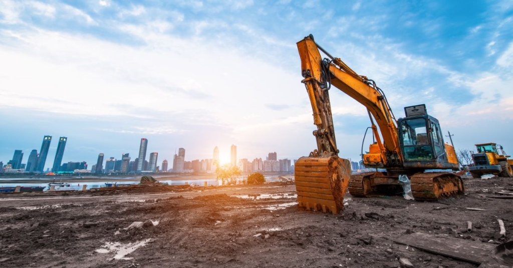 excavator on jobsite with sunrise in background.