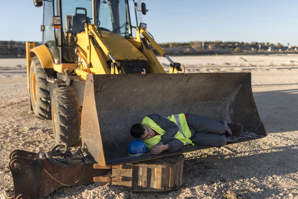 Construction worker sleeping on jobsite.