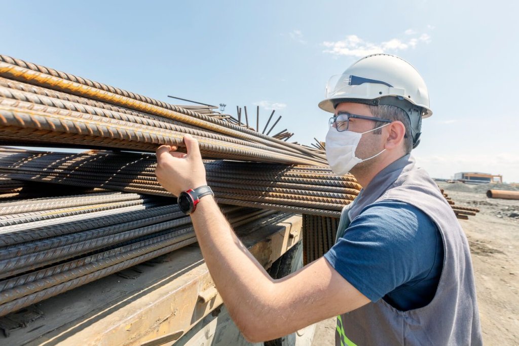 worker inspecting material on construction site.