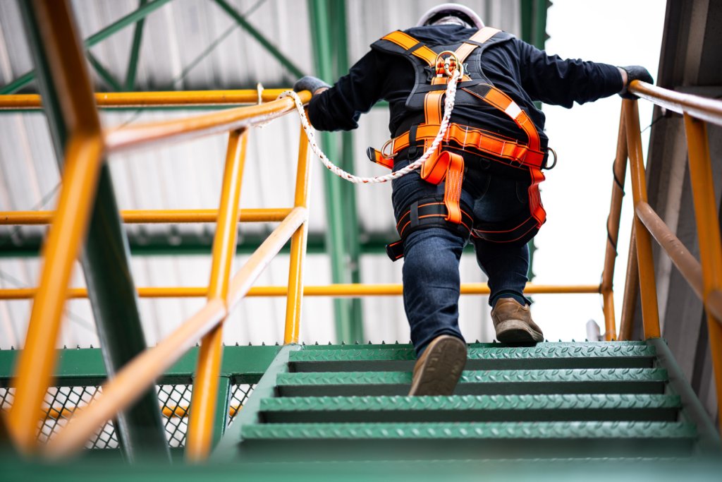 construction worker walking up levels with fall protection.