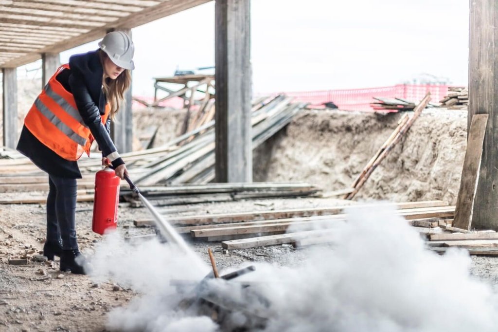 construction worker using fire extinguisher on a construction site.