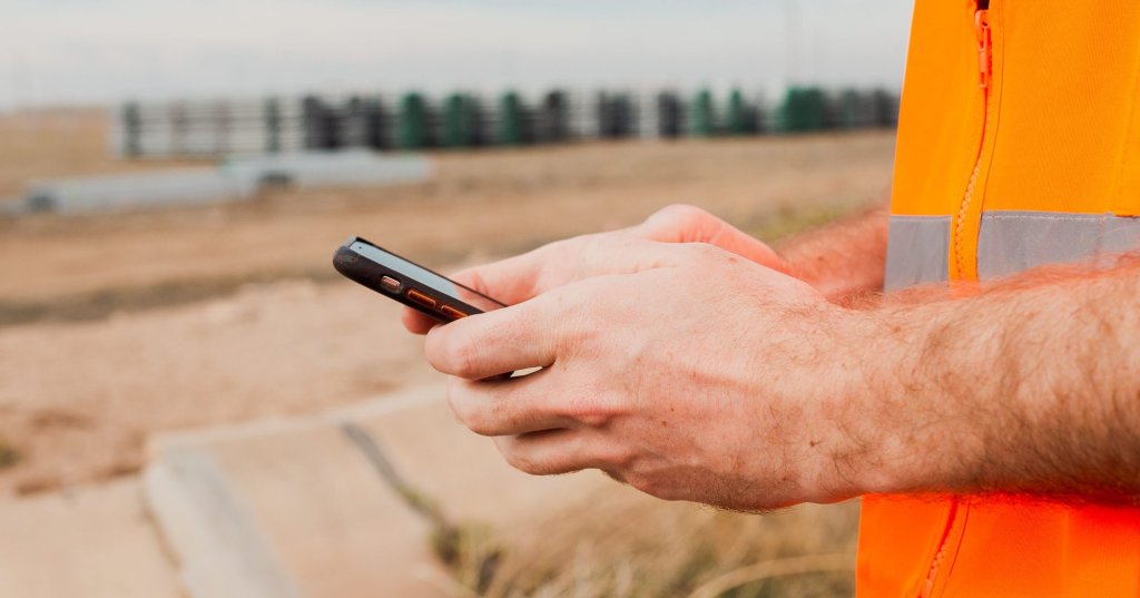 Construction worker using mobile phone on jobsite.