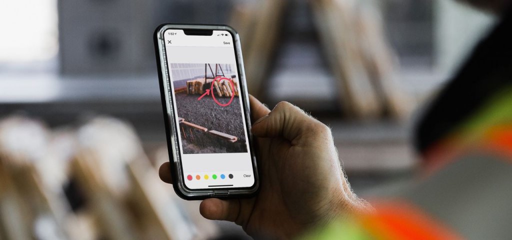Construction worker using photo documentation app on jobsite.