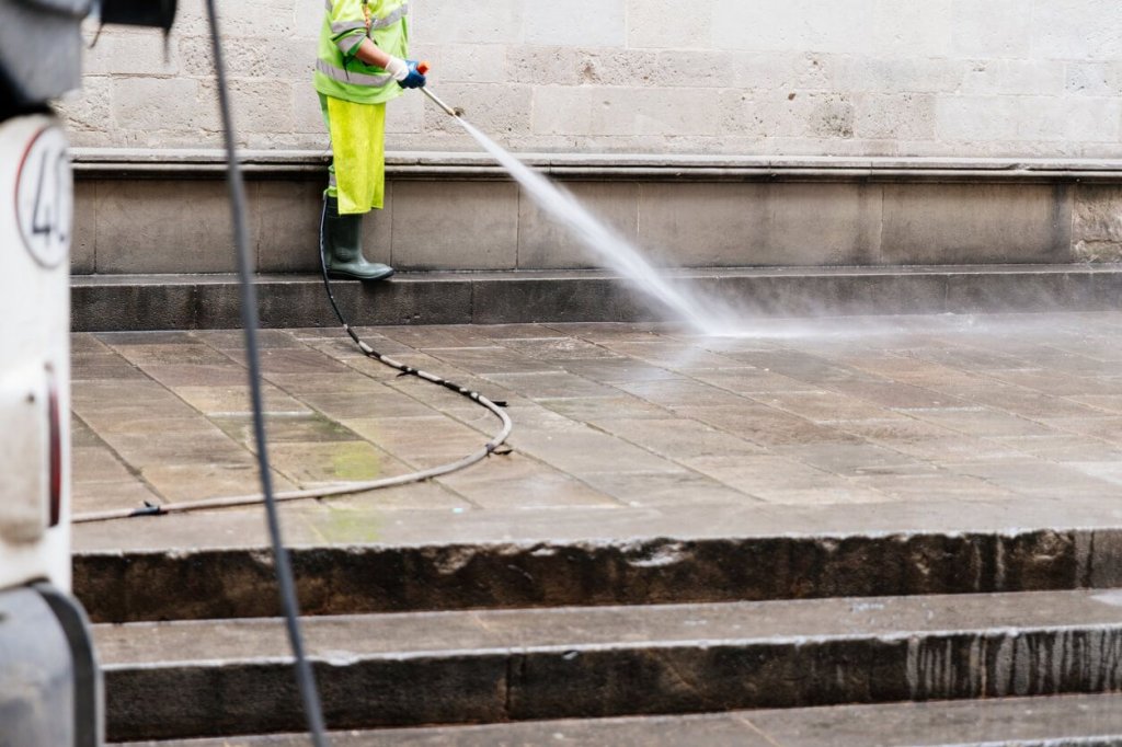 construction worker using pressure washer.