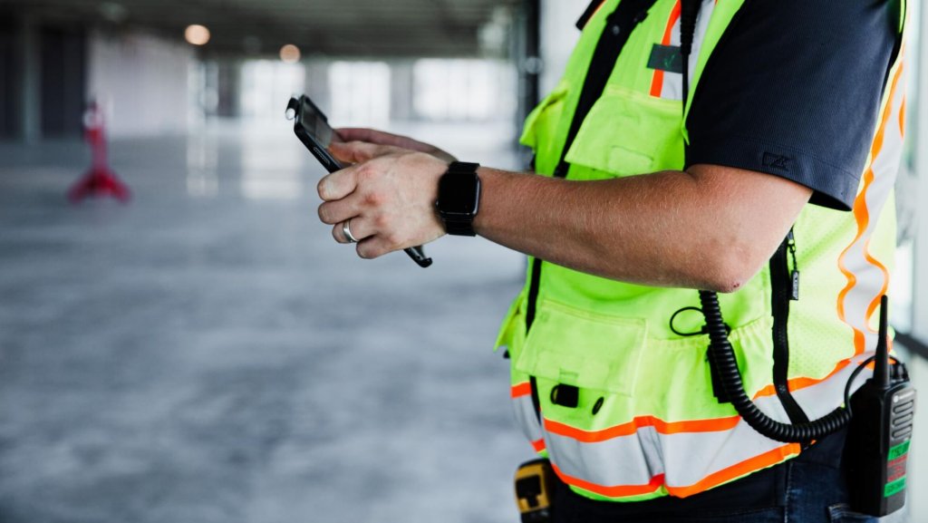 contractor using Raken construction software on tablet.