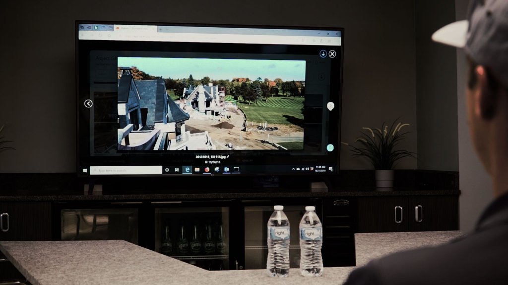 Contractor viewing jobsite photo on computer.