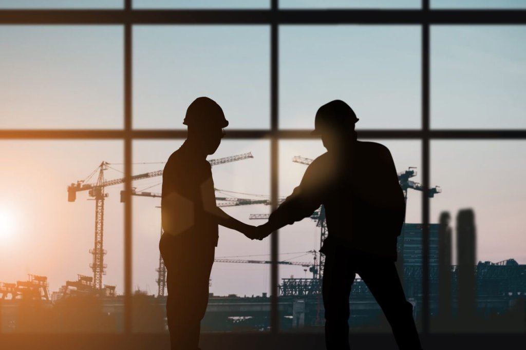 coworkers helping each other on a jobsite.