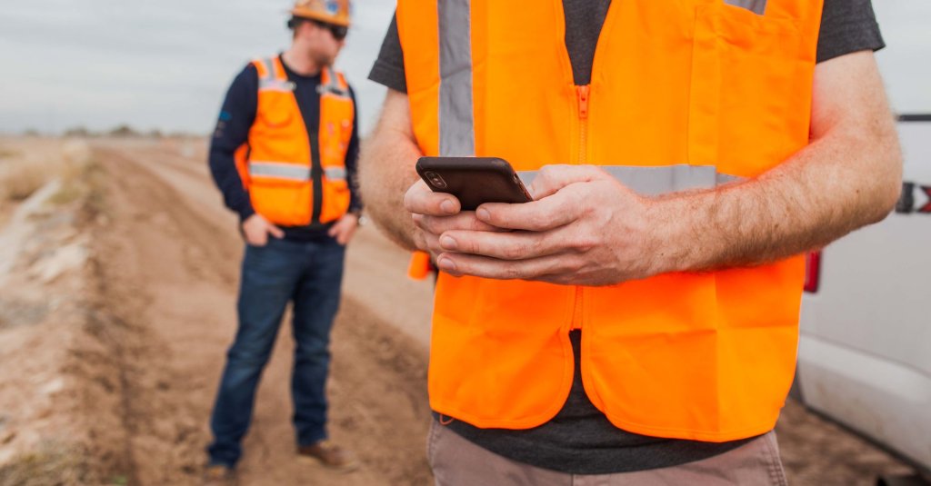 contractor using phone on jobsite.