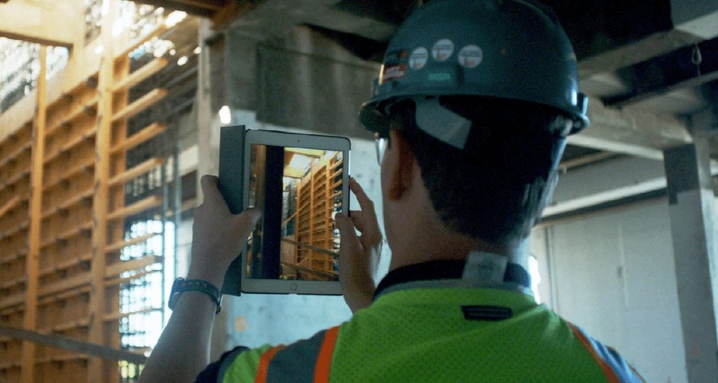 construction worker taking photo with ipad.