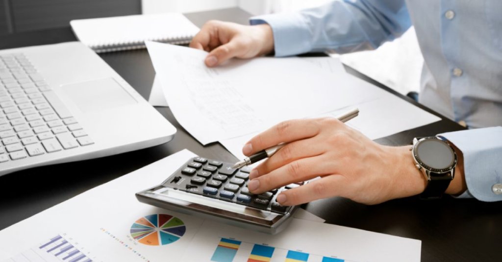 construction project manager using calculator for budgeting.