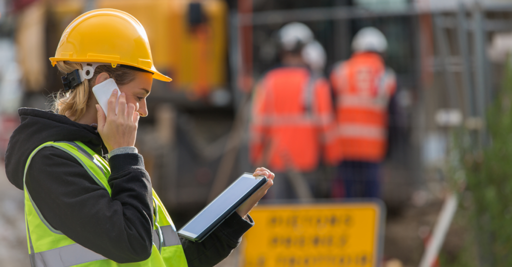 woman construction worker talking on mobile phone on jobsite.