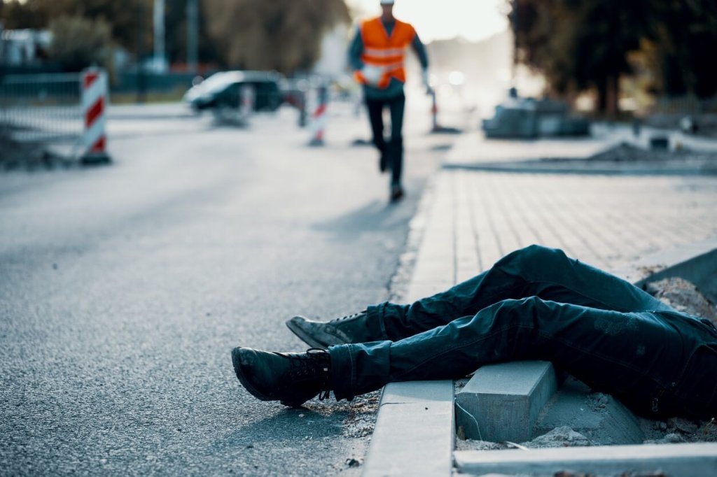 construction worker running towards injured person.