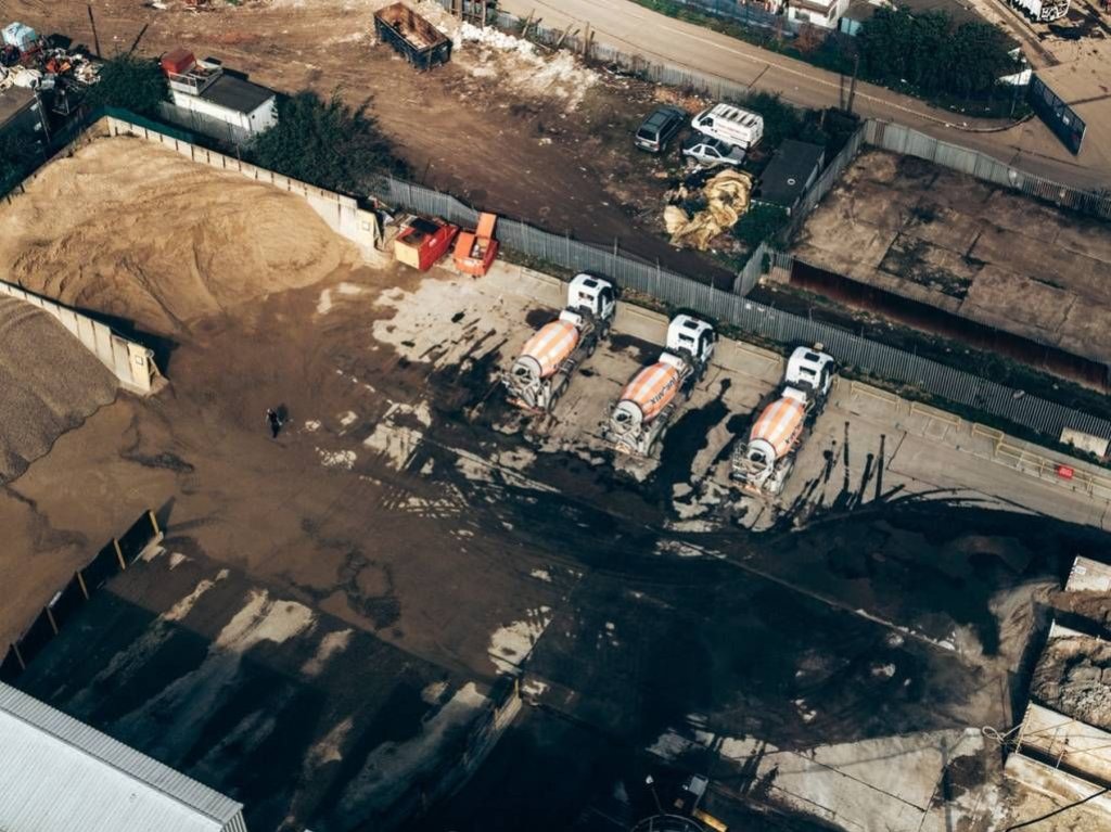 aerial view of construction site with concrete trucks.