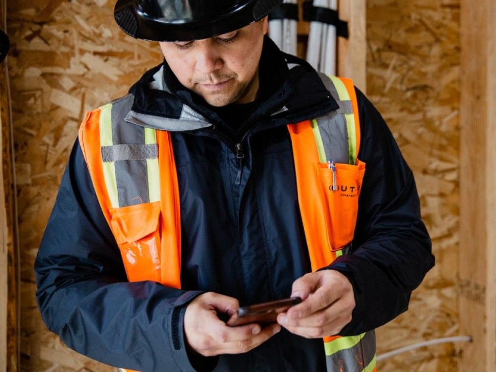 construction worker looking at phone.