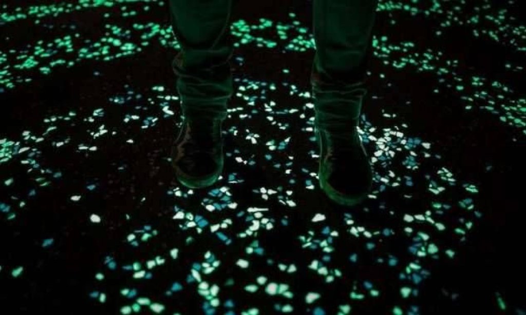feet standing on light emitting cement pavement.