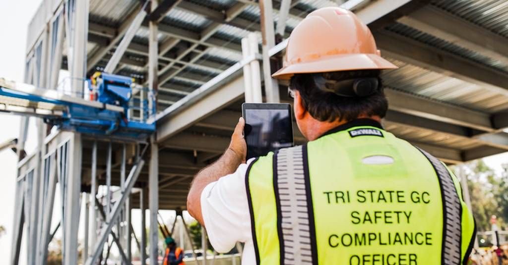 general contractor taking photo of jobsite with tablet.