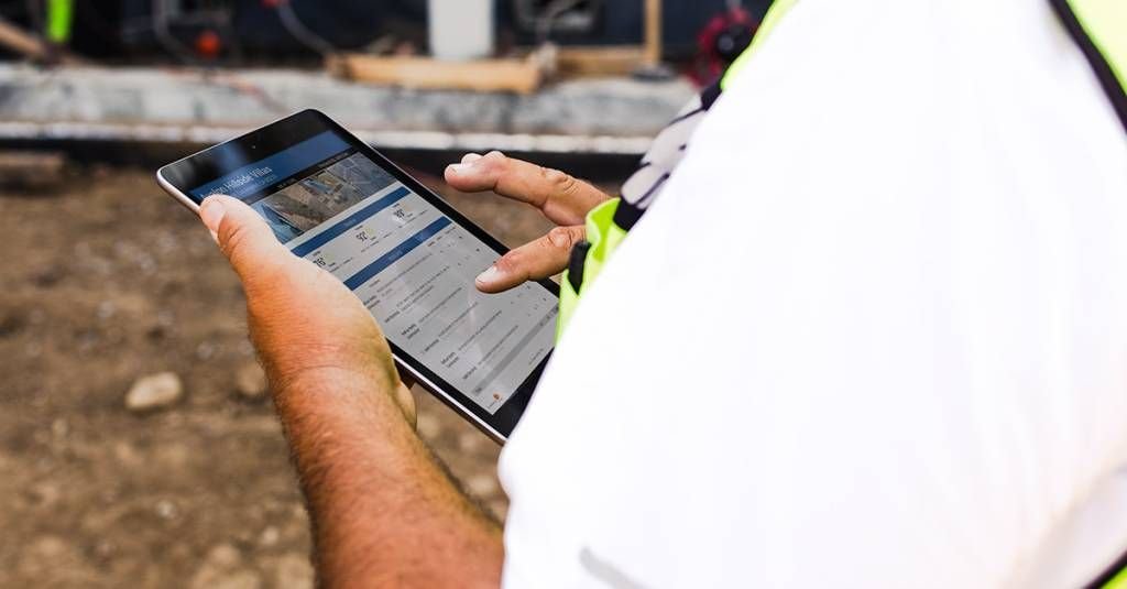 construction field manager using tablet on jobsite.