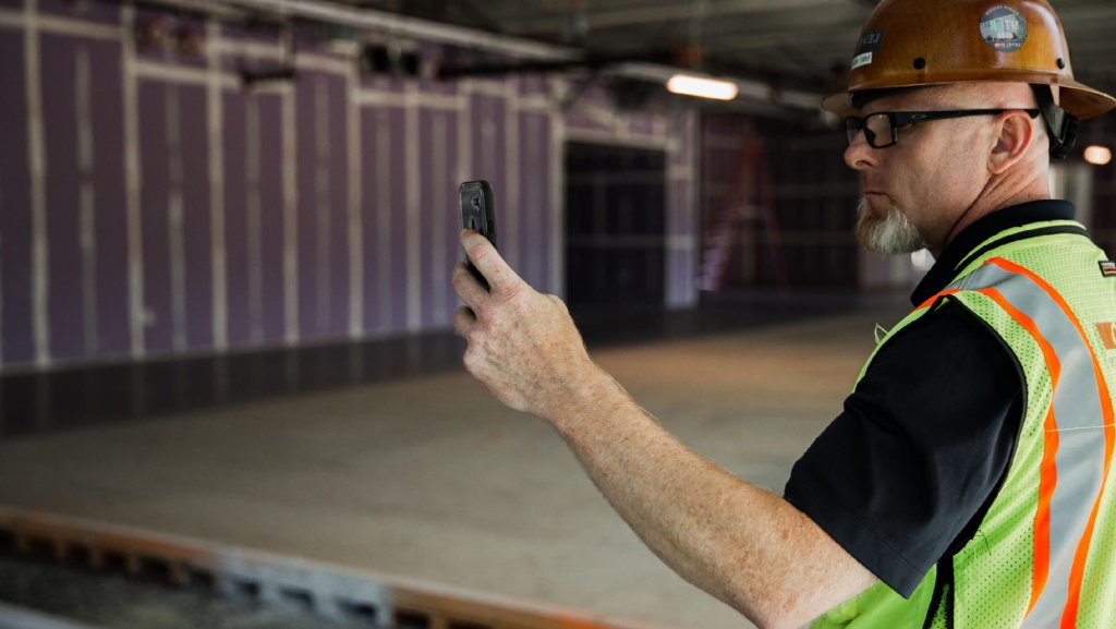 contractor using Raken app on jobsite.